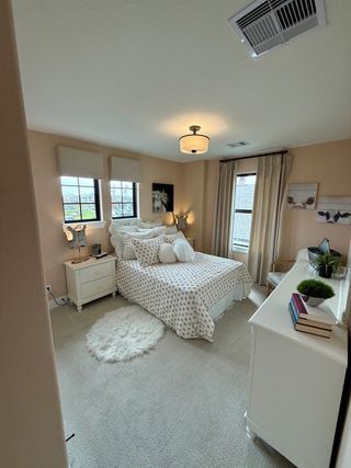 Cozy bedroom with soft neutral tones, plush bedding, and chic decor for a relaxing ambiance.