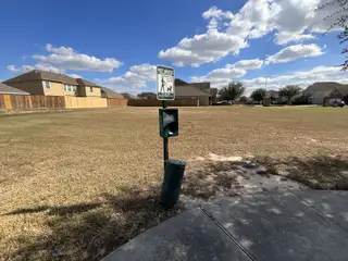 A spacious green area with pet waste station in Cypresswood Point by Long Lake Ltd. (Humble, TX), perfect for walks.