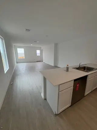 Model Home A spacious open-plan kitchen and living area with sleek countertops, minimalist cabinetry, and abundant natural light.