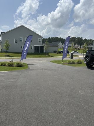 A welcoming new home community with lush greenery and Lennar banners in Edge of Auburn by Lennar (Raleigh, NC).