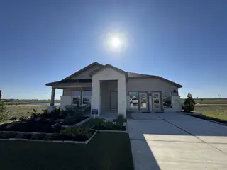 Street view A modern stone-accented home with a landscaped yard in Waterstone: Classic Collection by Lennar (Kyle, TX).