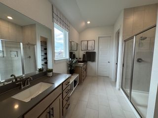 Model Home A modern bathroom featuring dual vanities, sleek countertops, a spacious shower, and elegant decor accents.