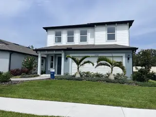 Street view A modern two-story home with a manicured lawn in Spencer Glen by Pulte Homes (Riverview, FL).