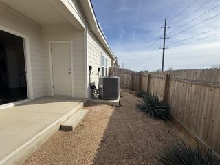 A cozy backyard with a concrete patio and privacy fence, perfect for relaxation and entertaining guests.