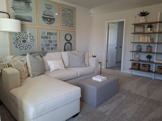 A cozy living area with a soft sectional, abstract wall art, and stylish shelving, creating a warm, inviting atmosphere.