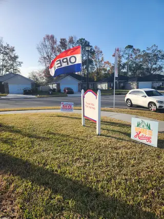 A bright view of a model home in the Summerglen community by Adams Homes (Jacksonville, FL), showcasing a neatly maintained front yard.