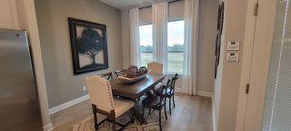 Model Home A cozy dining nook with elegant chairs, a stylish table, and large windows offering serene views.
