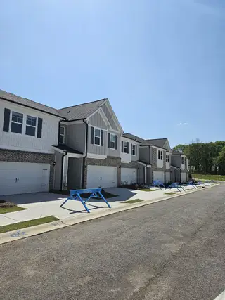 Stylish townhomes with modern exteriors and landscaped driveways in Diamante by DRB Homes (Stockbridge, GA).