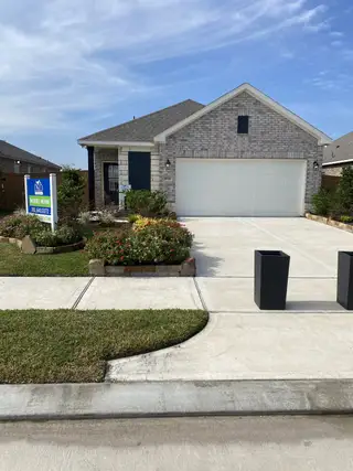 A charming brick home with a lush landscaped yard in Emberly by DSLD Homes (Beasley, TX).