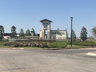 The grand entrance to Sunterra, showcasing elegant stone signage and beautiful landscaping, setting a welcoming tone for residents and visitors.