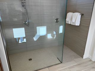 A sleek shower with modern glass doors, tiled walls, and a subtle stone floor for a luxurious bathing experience.