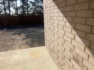 A newly constructed brick facade with adjacent patio in Parkerville Meadows by D.R. Horton, DeSoto, TX.