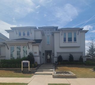 A modern gray home with lush landscaping in Estate 64s by Landon Homes (Frisco, TX).