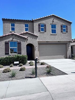 A beautiful beige stucco home with elegant shutters and low-maintenance landscaping in Tierra La Bella by KB Home (Phoenix, AZ).