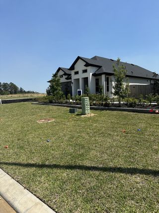 Street view A modern home with black roofing and manicured landscaping in Montgomery Bend by Pulte Homes (Montgomery, TX).