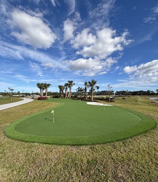 A picturesque golf area with palm trees and vibrant grass in The Timbers at Everlands by Lennar (Palm Bay, FL).