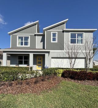 A modern gray home with striking architecture and a vibrant lawn in Buena Lago by D.R. Horton (St. Cloud, FL).