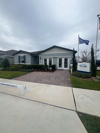 Charming model home with paved driveway and lush landscaping in Eden Hills by Meritage Homes (Lake Alfred, FL).