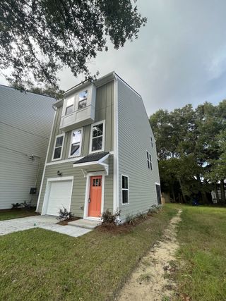 A charming modern home with a vibrant orange door in Rivers Edge by DRB Homes, North Charleston, SC.