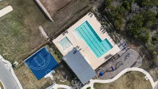 The resort-style pool at Crescent Bluff by Pulte Homes in Georgetown, TX, featuring lap lanes, a sundeck, and relaxing lounge seating.