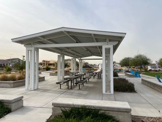 A modern community pavilion with seating in Highland Ridge at Alamar by Brookfield Residential (Avondale, AZ).