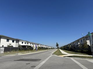 Modern row of white homes lining a quiet street in On Alba by Onx Homes, Florida City, FL.