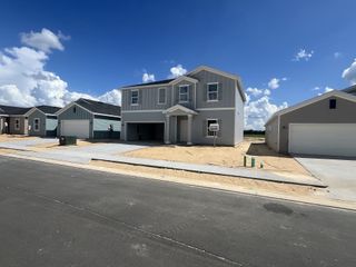 A modern gray home with clean lines and a spacious driveway in Pioneer Ranch: Pioneer Ranch 50's by Lennar (Ocala, FL).