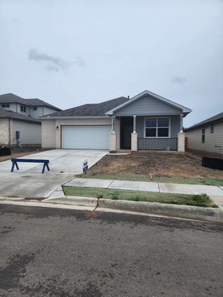 Street view A modern single-story home with a welcoming porch in Talavera by D.R. Horton (Kyle, TX).