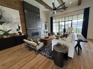 A luxurious living room with wood accents, a sleek fireplace, and expansive windows offering natural light.