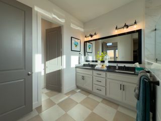 A bright bathroom with a double vanity, modern lighting, and decorative touches in a sleek, contemporary design.