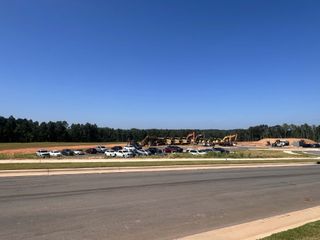 A new development site with construction vehicles and parked cars in Carolina Riverside by Del Webb (Belmont, NC).