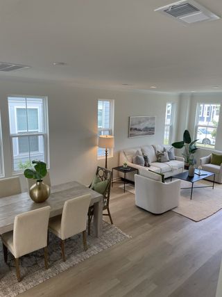 Model Home A modern, open-concept living and dining area featuring soft neutral tones and stylish decor.