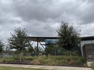 A contemporary home with sleek glass and lush landscaping in Urban Homes at Easton Park by Brookfield Residential (Austin, TX).