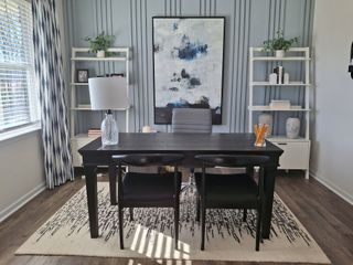 Model Home A modern home office with a sleek black desk, abstract art, and built-in shelves.