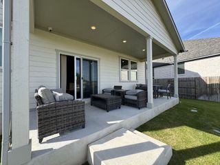Model Home A cozy patio with wicker furniture and a neat lawn, perfect for outdoor relaxation and entertaining guests.
