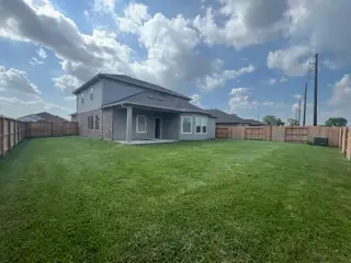 A spacious two-story home with a vast fenced yard in Wall Street Village by Meritage Homes (Richmond, TX).