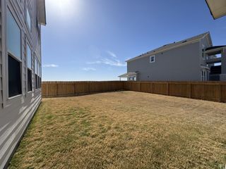 Street view A spacious backyard with a wooden fence in Enclave at Cele by Saratoga Homes (Pflugerville, TX).