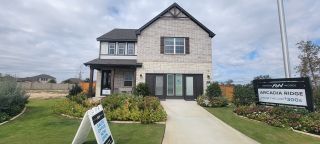 A charming light brick home with a landscaped yard in Arcadia Ridge by Ashton Woods (San Antonio, TX).