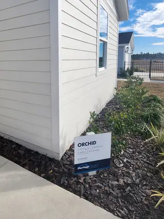 A charming light-colored home with modern siding in Lakes at Bella Lago – Signature Series by Meritage Homes (Green Cove Springs, FL).