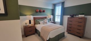 Model Home A cozy bedroom with basketball-themed decor, a plush bed, wooden furniture, and soft lighting.