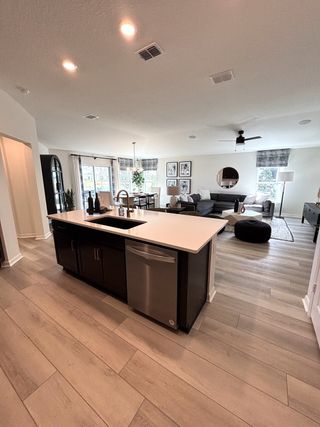 An open-plan kitchen and living area with a sleek island, elegant lighting, and cozy seating, perfect for entertaining.