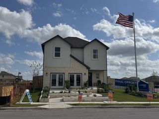 A beautiful modern home with a landscaped yard in Village at Manor Commons by Landsea Homes (Manor, TX).