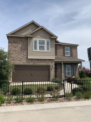 A charming brick home with a manicured yard in Sonterra - Cool Water by KB Home (Jarrell, TX).