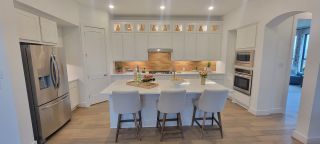 The kitchen offers an open-concept layout with modern appliances, sleek countertops, and a beautiful backsplash.