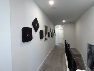 A stylish hallway with contemporary art on the walls, showcasing the modern design of this home.
