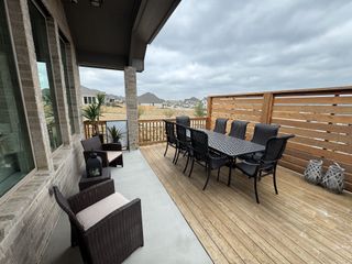 A covered patio oasis featuring stylish outdoor seating and dining area, perfect for entertaining in Veramendi by Coventry Homes (New Braunfels, TX).