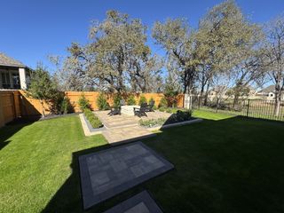 Model Home An inviting outdoor living space with a fire pit, seating area, and lush landscaping, perfect for relaxing evenings.