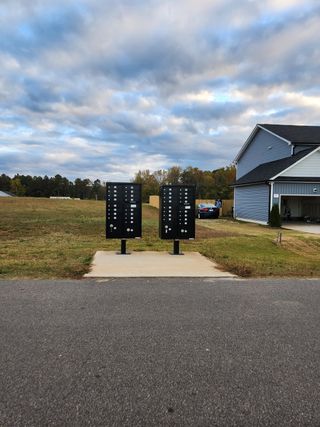 Street view Community mailboxes and a modern home in the scenic Olde Place by RiverWILD Homes (Zebulon, NC).