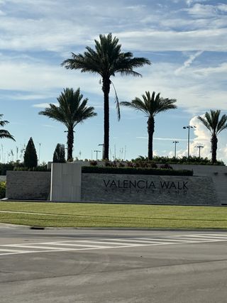Street view Entrance to Valencia Walk at Riverland by GL Homes, featuring lush palm trees and clean landscaping in Port St. Lucie, FL.