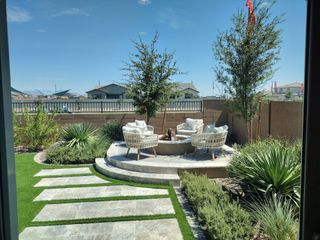 Model Home A beautifully landscaped patio with modern seating and greenery, perfect for outdoor relaxation.